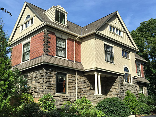 photo of Victorian home in Chestnut Hill, PA with cedar shake siding and arched windows. Old Village Master Painters repainted the cedar shakes and window trim to match old photos